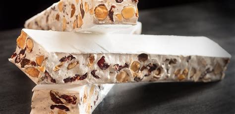 Masa de turrón siendo mezclada con frutos secos calientes.