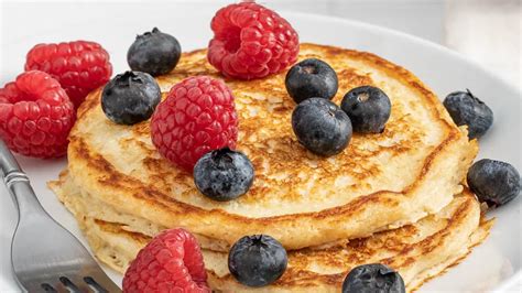 Fotografía de primer plano: Panqueques de avena dorados y esponjosos con frutas frescas encima