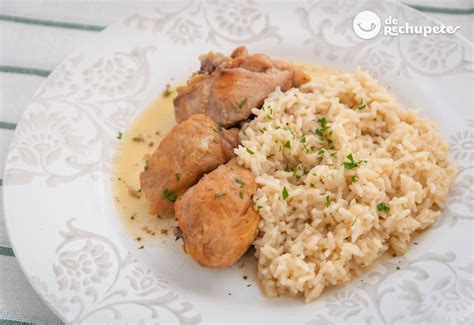 Plato de pollo al vino blanco acompañado de arroz blanco, presentado con hierbas frescas.