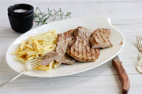 Fotografía gastronómica de un filete de ternera salseado con una cremosa salsa de aceitunas negras y hierbas frescas.