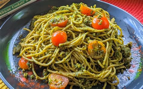 Plato de pasta al pesto con queso de cabra desmenuzado y tomates cherry salteados
