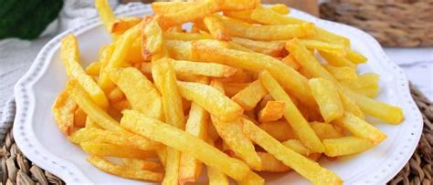 Plato de papas fritas doradas y crujientes con sal.