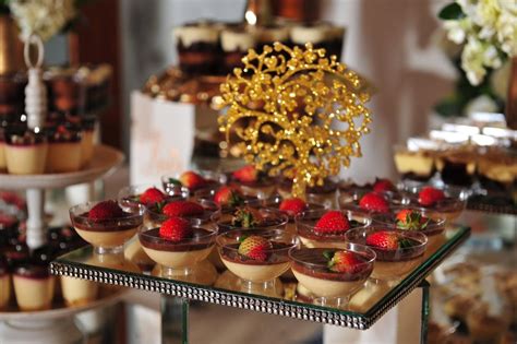 Una mesa elegante con varios postres y dos personas compartiendo uno.