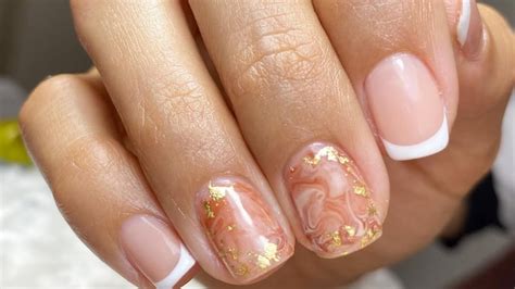 Diseño de uñas cortas con efecto marmoleado en rosa pastel y blanco