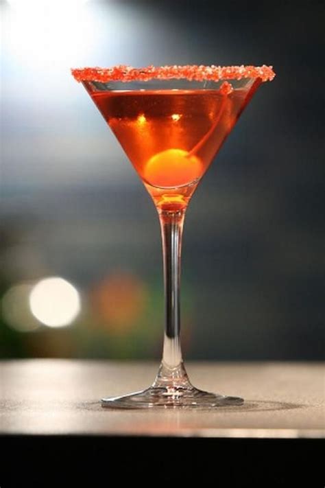 Copa de Martini escarchada con azúcar negra, conteniendo un cóctel oscuro