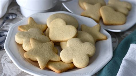 Bandeja con galletas de mantequilla dispuestas para hornear, con formas variadas.