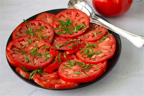 Foto cenital de una pizza artesanal con huevos horneados, rodajas de tomate fresco, albahaca y una base crujiente.
