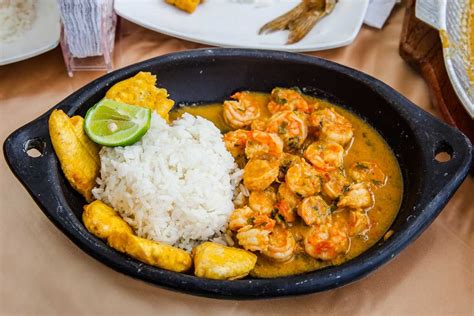 Plato de encocado de camarón con arroz blanco y plátanos fritos