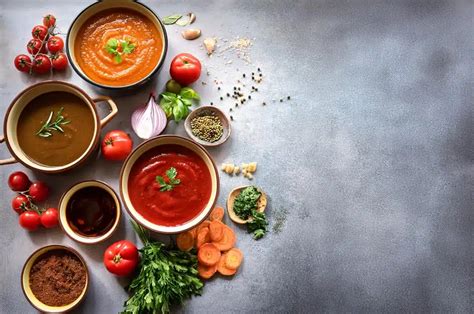 Variedad de salsas en recipientes pequeños junto a bastones de vegetales frescos