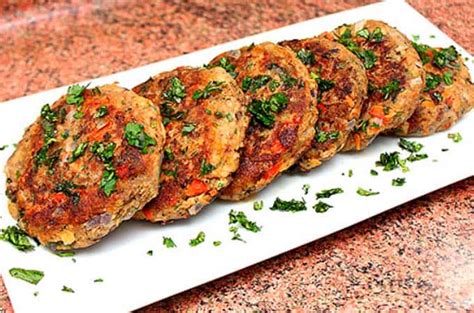 Croquetas de jurel recién formadas y rebozadas, separadas en una bandeja lista para la congelación individual.