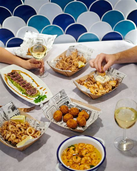 Variedad de tapas de pescado y marisco en una barra española