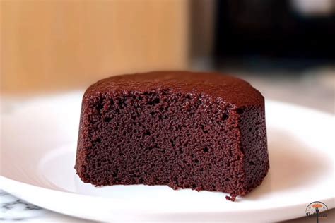Fotografía de un bizcocho de chocolate esponjoso recién salido del horno sobre una rejilla.