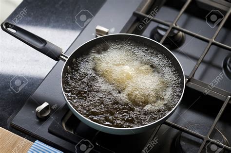 Albóndigas dorándose en una sartén con aceite caliente.