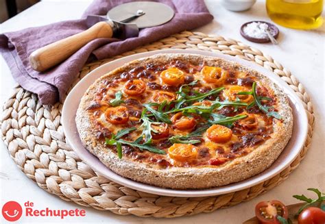 Masa de pizza integral con ingredientes sobre una tabla de madera