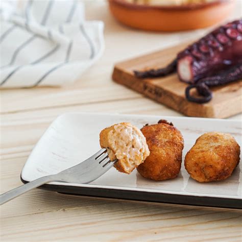 Imagen de croquetas de pulpo doradas y crujientes servidas en un plato