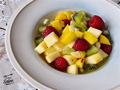 Una macedonia de frutas de colores vibrantes, preparada en un bol