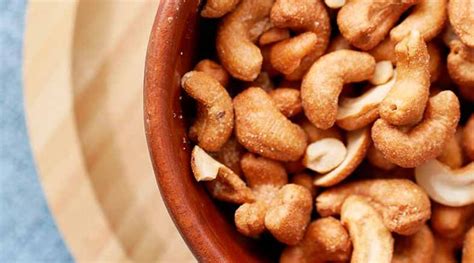 Primer plano de nueces de la India tostadas y crudas, destacando su forma y textura.