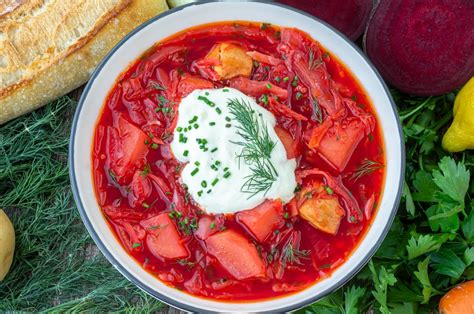 Foto de un tazón de borsch caliente con crema agria y eneldo fresco