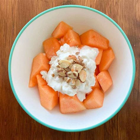 Plato de papaya con queso cottage y salsa de arándanos, presentado de forma atractiva.
