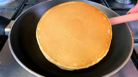 Primer plano de un hot cake en la sartén con la espiral de canela siendo dibujada