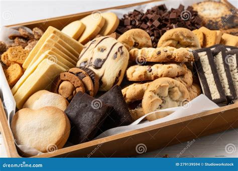 Fotografía de una bandeja de galletas variadas, incluyendo galletas de pasta seca y galletas tipo triángulos de requesón con azúcar.