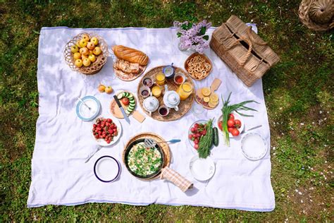 Imagen de un picnic primaveral con cesta, mantel a cuadros y comida variada