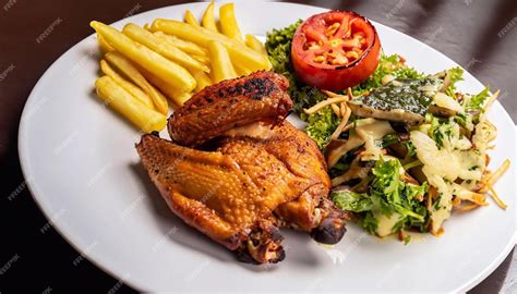 Plato de pollo a la brasa con papas fritas y ensalada fresca