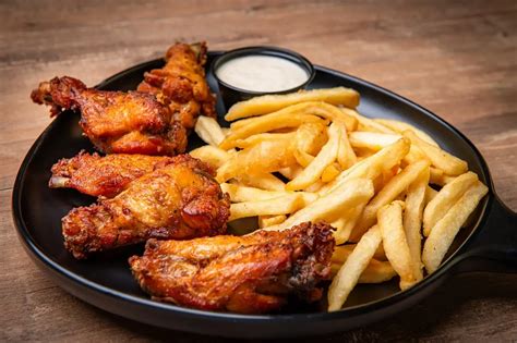 Ilustración de alitas de pollo crujientes y papas fritas