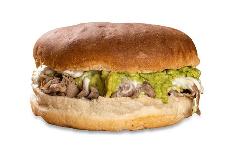 Fotografía gastronómica de un churrasco en pan frica con palta y tomate, mostrando la jugosidad del corte.