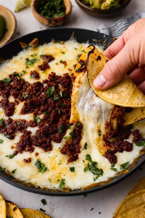 Carne molida aplanada con capas de queso, chorizo, espinacas y queso rallado, lista para enrollar
