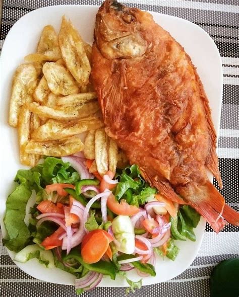 Foto de pescado frito servido con ensalada y papas