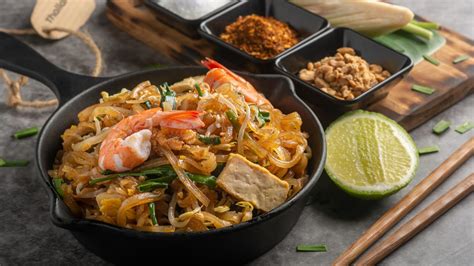 Imagen de un Pad Thai colorido con fideos de arroz, gambas, cacahuetes y lima.