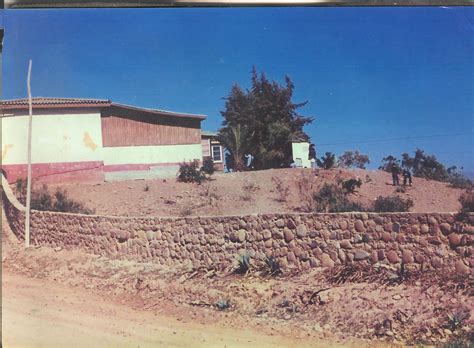 Fachada lateral de la Escuela Mixta F-26 de Altovalsol, mostrando su construcción de adobe y madera.