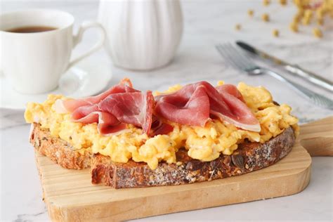 Infografía con los ingredientes principales de las tostadas con huevos fritos y bacon: pan tostado, huevos fritos, bacon crujiente.