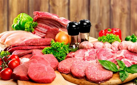 Imagen de una mesa variada con diferentes tipos de carnes y achuras en una parrillada.