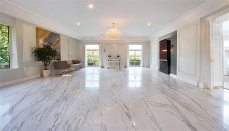 Galería de imágenes mostrando diferentes aplicaciones del mármol blanco en interiores: pisos, encimeras, revestimientos y muebles