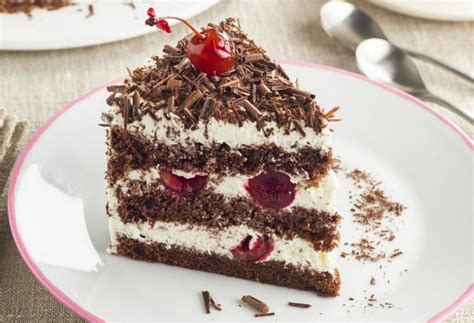 Ilustración de una Tarta Selva Negra tradicional con capas de bizcocho de chocolate, nata y cerezas, decorada con virutas de chocolate.