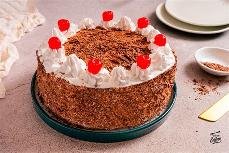 Fotografía detallada mostrando cómo decorar una Tarta Selva Negra con lascas de chocolate.
