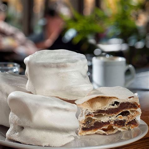 Fotografía histórica o recreación de un alfajor santafesino tradicional bañado en merengue.