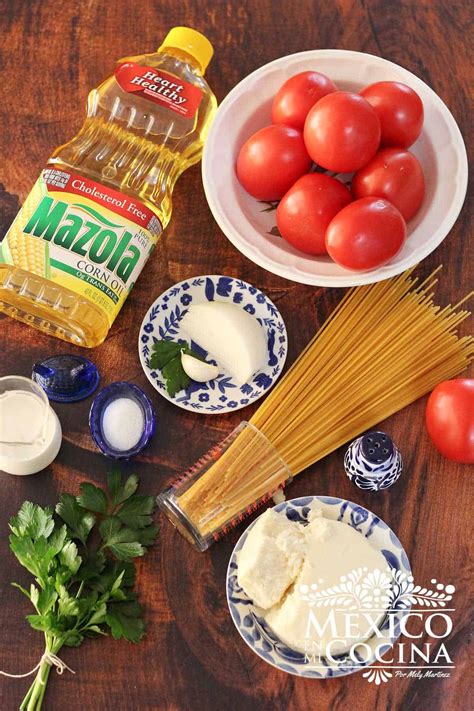 Ingredientes frescos para la salsa de espagueti: jitomates, cebolla, ajo, puré de tomate, consomé, laurel y orégano.