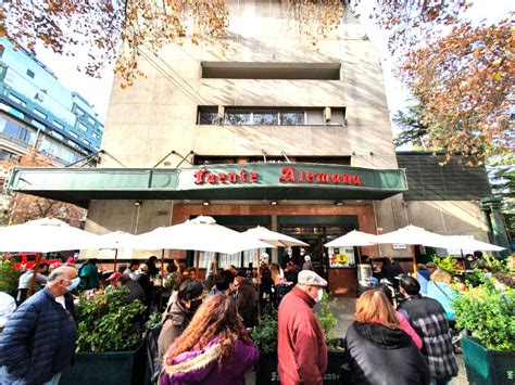 Fotografía histórica de la barra de la Fuente Alemana original, destacando la interacción entre los maestros sangucheros y los clientes.