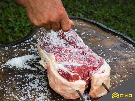 ilustración mostrando cómo aplicar sal gruesa a un bistec antes de la última vuelta