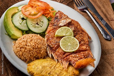 Plato de pescado frito al estilo caribeño con patacones, arroz con coco y ensalada