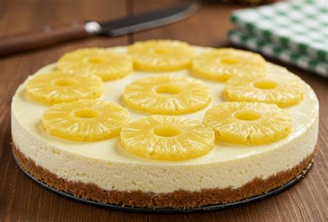 Fotografía profesional de una tarta de piña y queso decorada con frutas tropicales