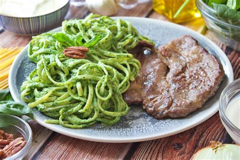 Plato de tallarines verdes peruanos recién preparados con salsa cremosa