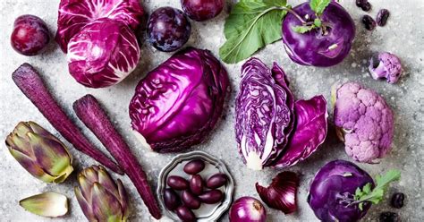 Variedad de frutas y verduras de color morado, como berenjenas, arándanos, col morada, uvas y remolacha