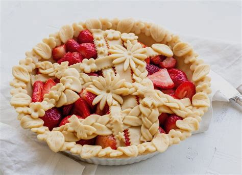 Foto de un pie de frutilla con elementos decorativos de masa colocados antes de hornear
