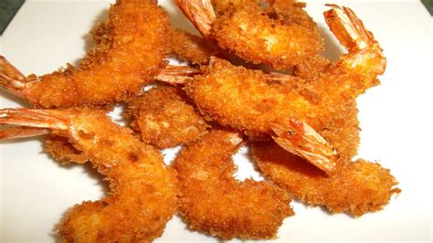 Camarones empanizados con panko y dorados, listos para servir en brochetas.