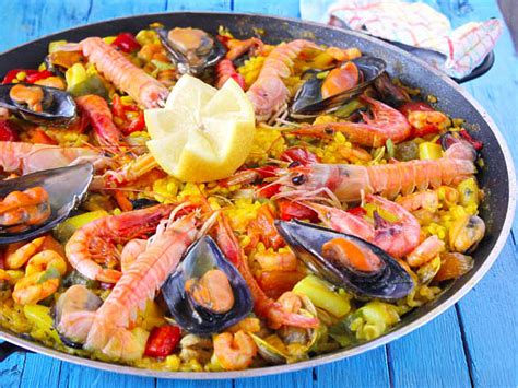 Fotografía de una paella colorida y apetitosa, repleta de mariscos y verduras.