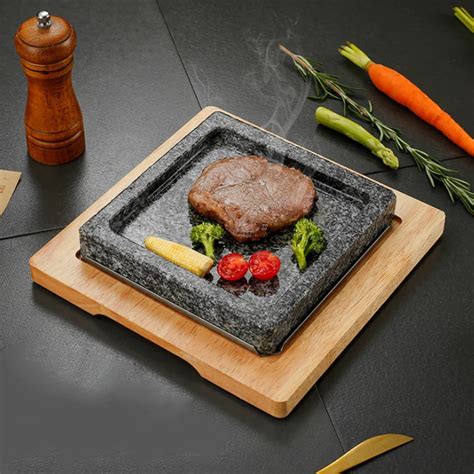 Plato de anguila a la parrilla servido en piedra caliente con verduras